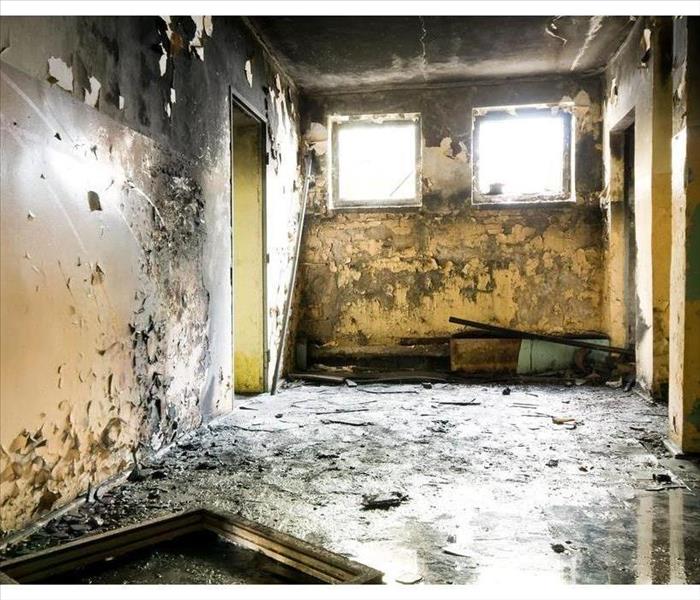 Ceiling and walls covered with smoke and soot, water on the floor